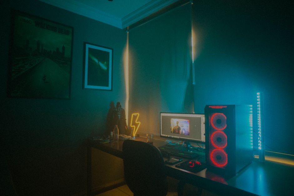 A colorful gaming setup with a monitor and LED lights in a cozy room.