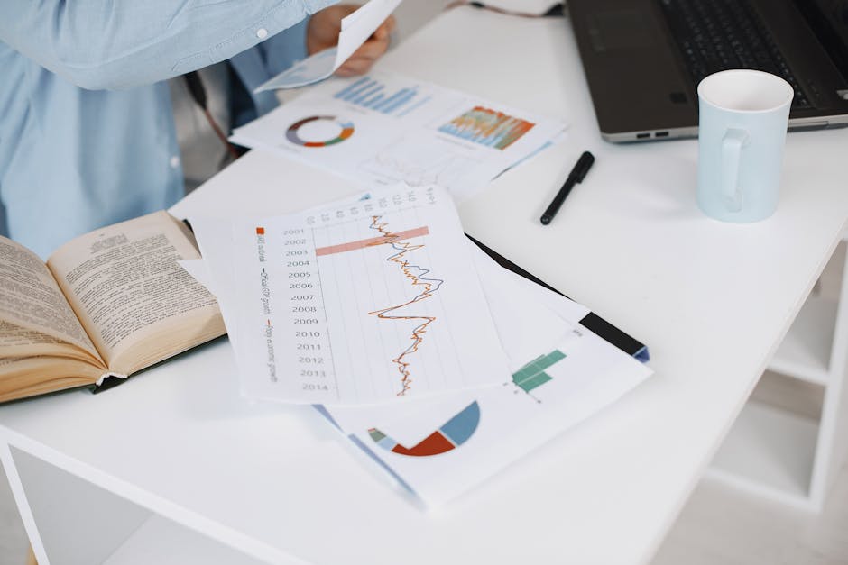 A modern workspace with a laptop and financial graphs on a desk