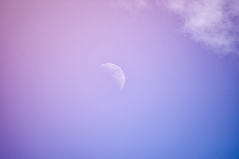 A night sky with crescent moons and soft clouds in deep blues and purples.