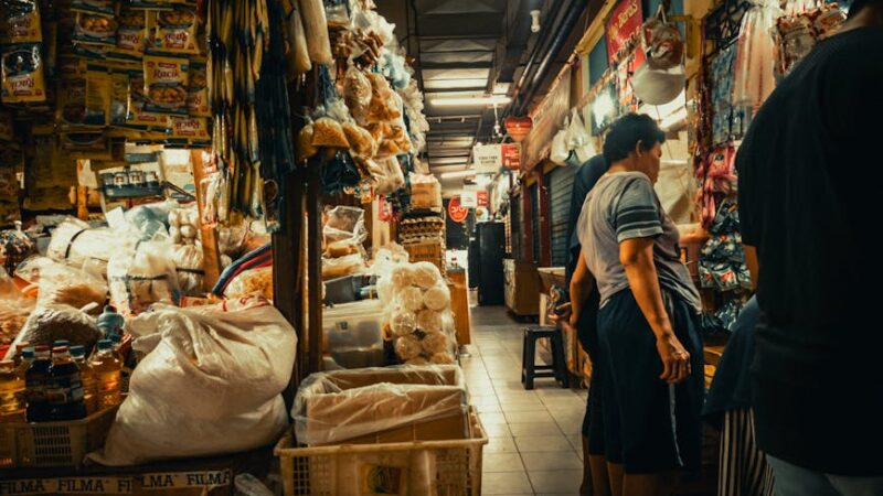 A lively marketplace filled with shoppers and colorful product displays.