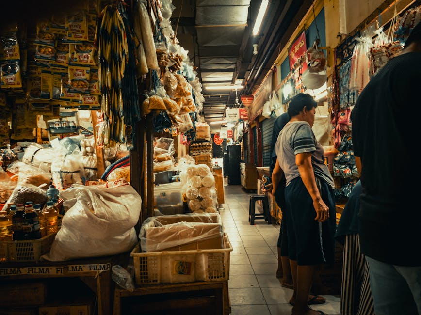 A lively marketplace filled with shoppers and colorful product displays.