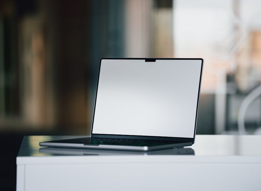 A modern workspace with a laptop and digital currency icons on the screen.