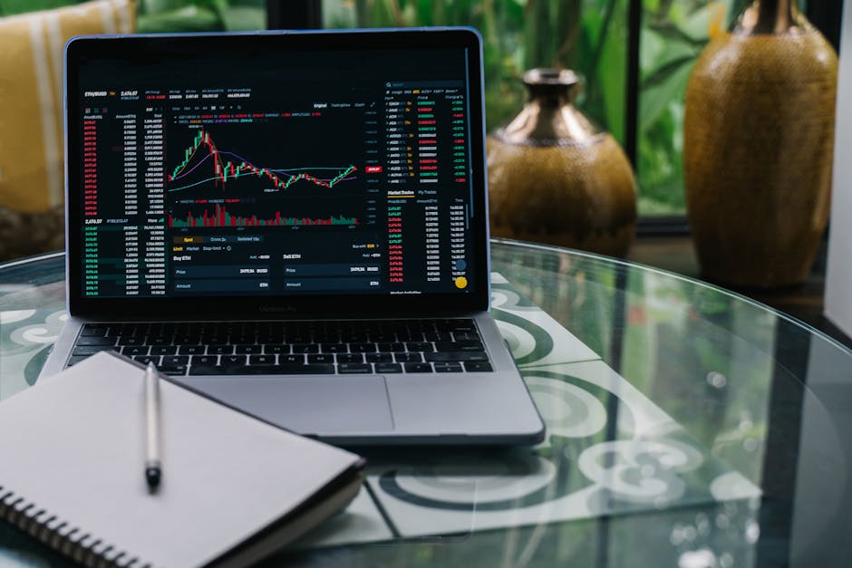 A modern workspace with a laptop and cryptocurrency coins on a desk.
