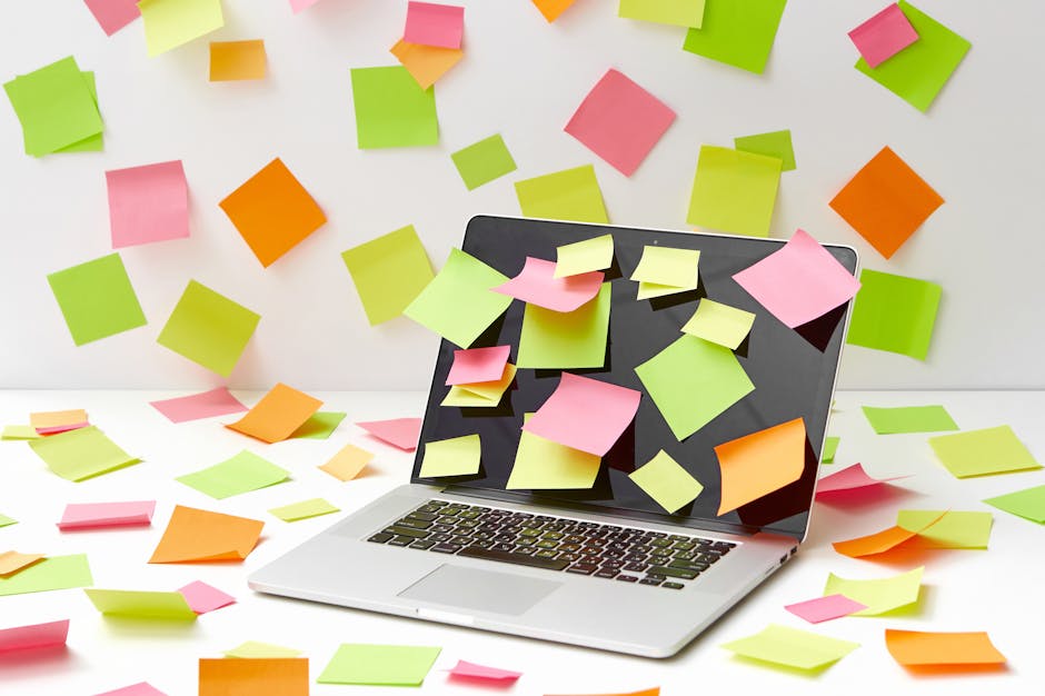 A modern workspace with a laptop, sticky notes, and creative tools.