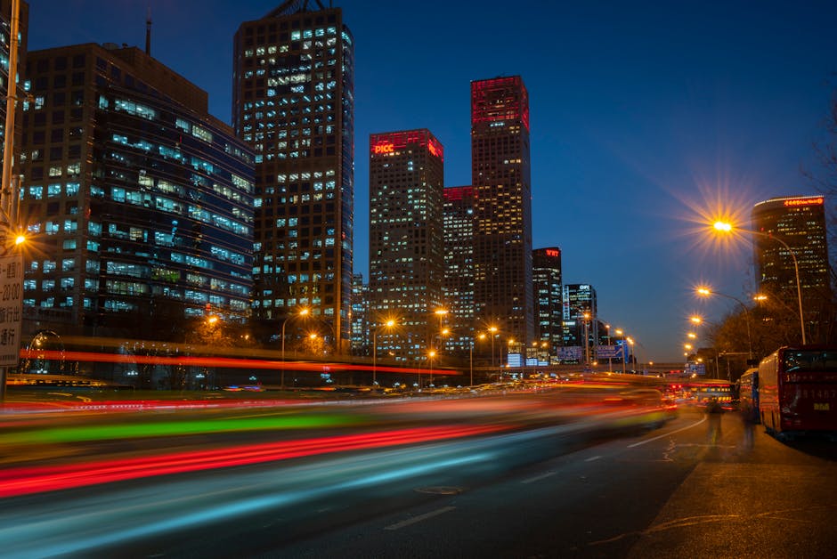 A vibrant city skyline at dusk with bright lights and silhouettes of people.