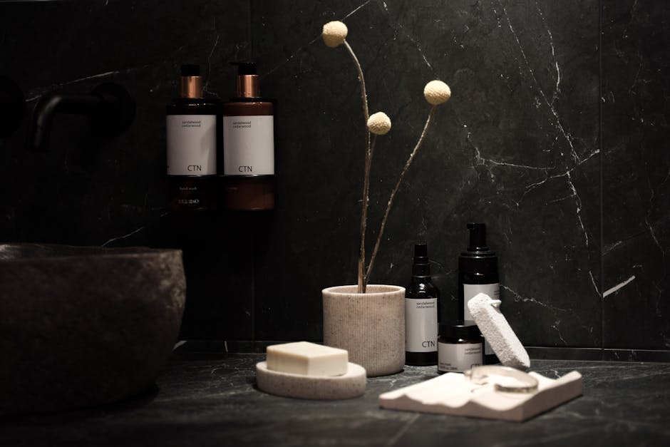 Elegant skincare products on a marble countertop with plants and tea.