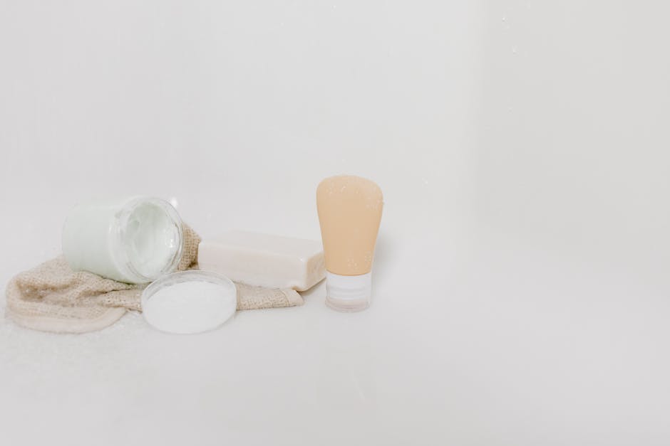 A bathroom countertop with skincare products and flowers in soft light.