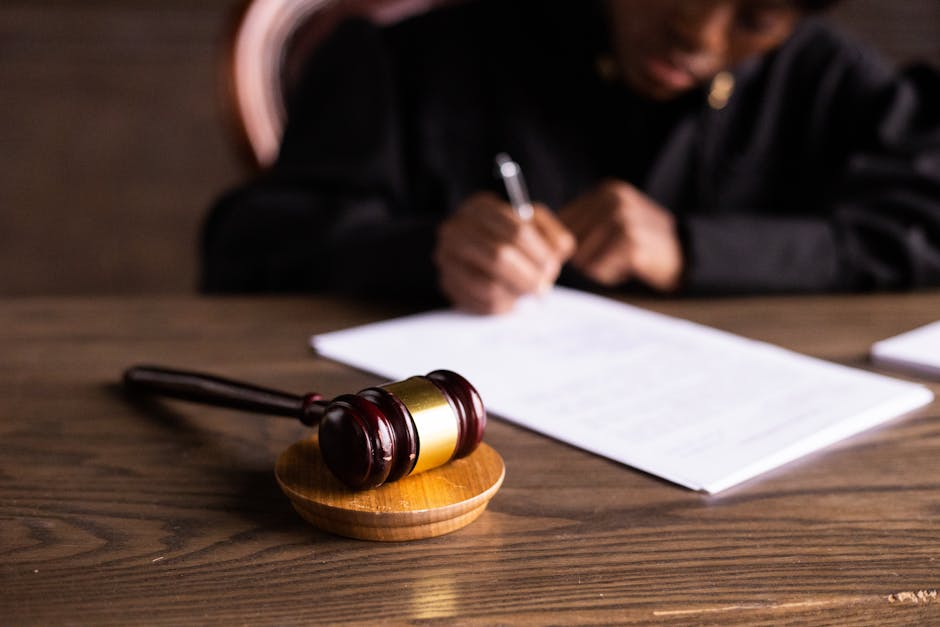 A blurred courtroom scene with a gavel and legal books in soft focus.
