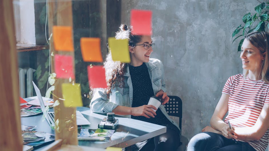 A creative workspace with a laptop and colorful sticky notes.