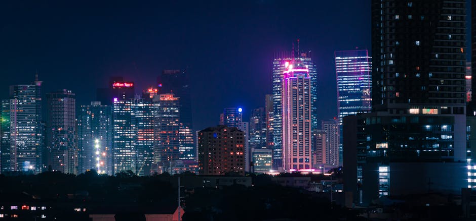 Futuristic city skyline with neon lights and water reflections at dusk.