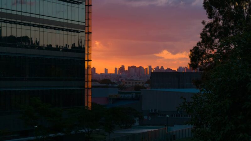 City skyline at dusk with vibrant lights and colorful sky