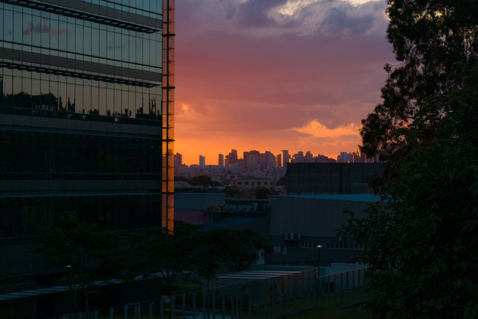 City skyline at dusk with vibrant lights and colorful sky