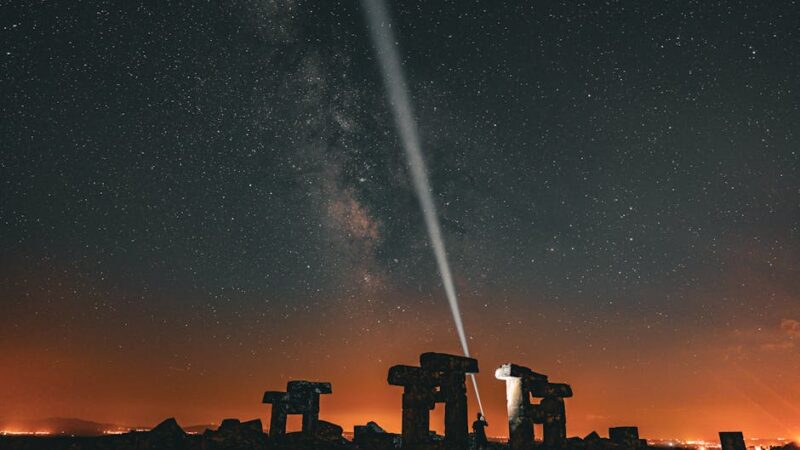 Silhouette of an ancient artifact against a starry night sky.