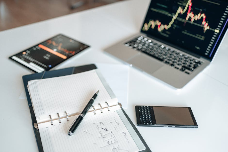 A modern workspace with a laptop and financial charts on a desk.