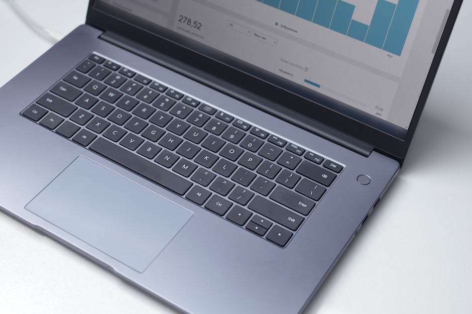 A modern workspace with a laptop displaying financial graphs and charts.