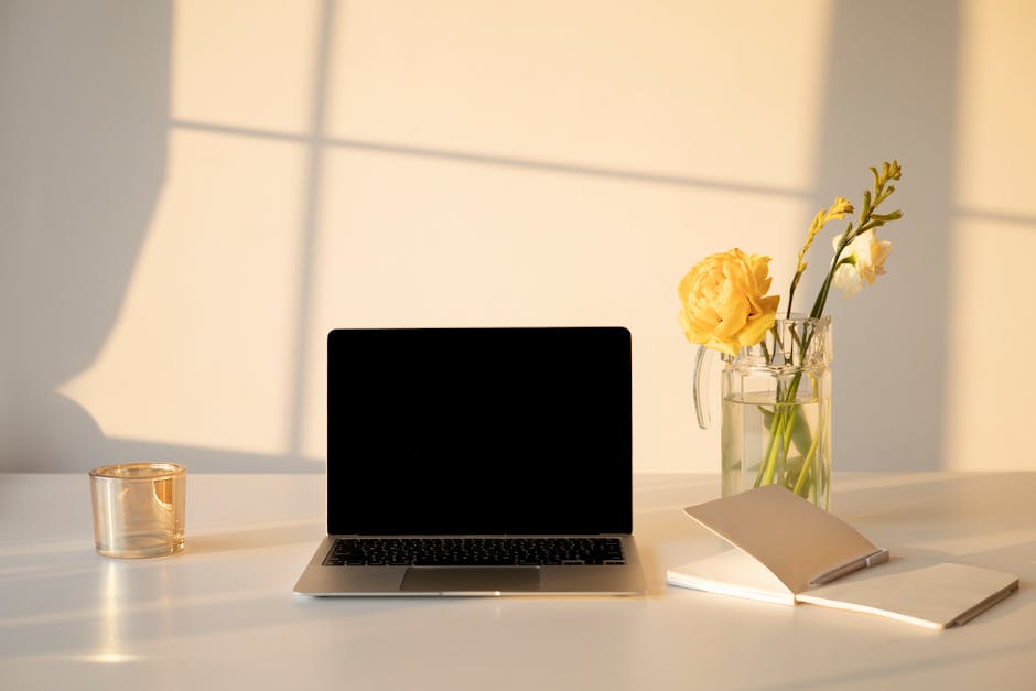 A modern study desk with a laptop, notebooks, and coffee in soft light.
