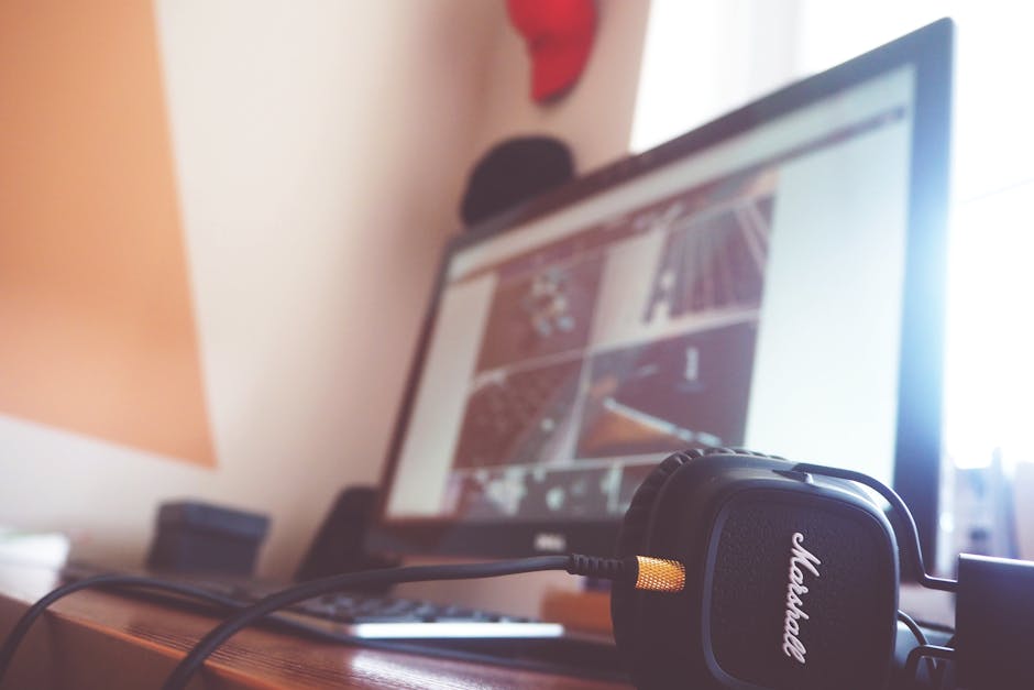 A creative workspace with audio equipment and modeling software on screen.