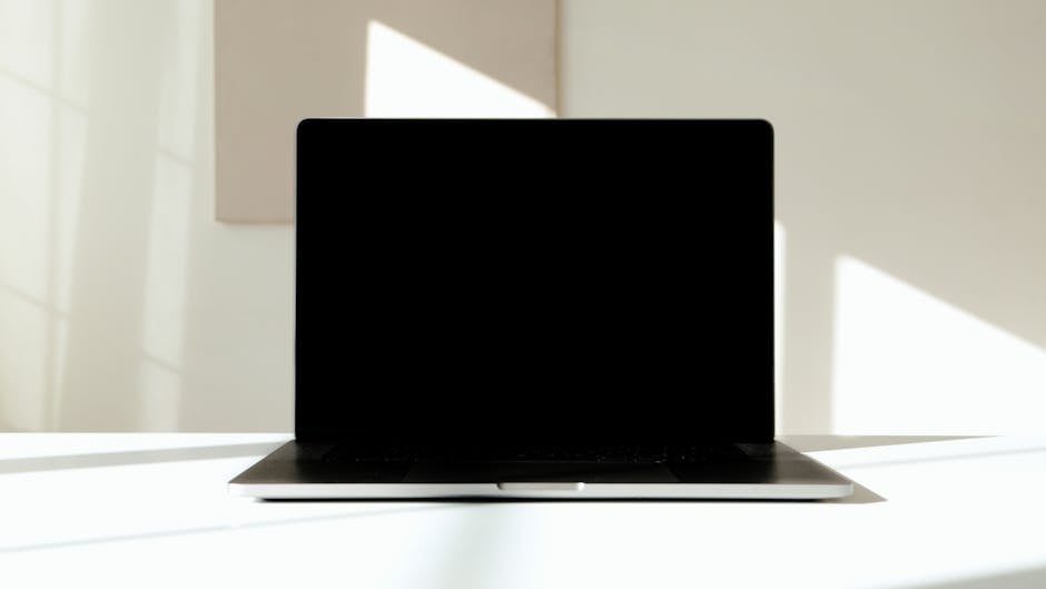 A modern workspace featuring a laptop and tech gadgets on a desk.