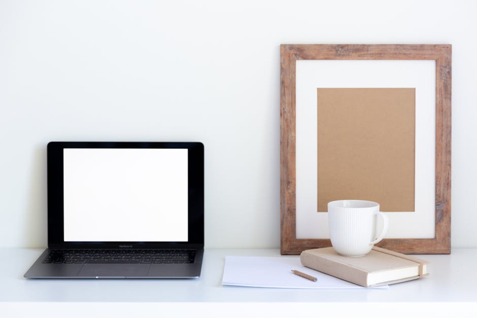 A minimalist workspace with a laptop, notepad, and coffee cup