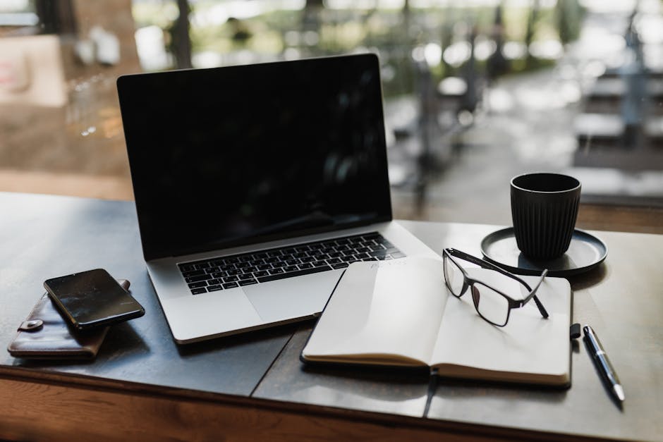 A cozy workspace featuring a laptop, books, and coffee on a wooden desk.