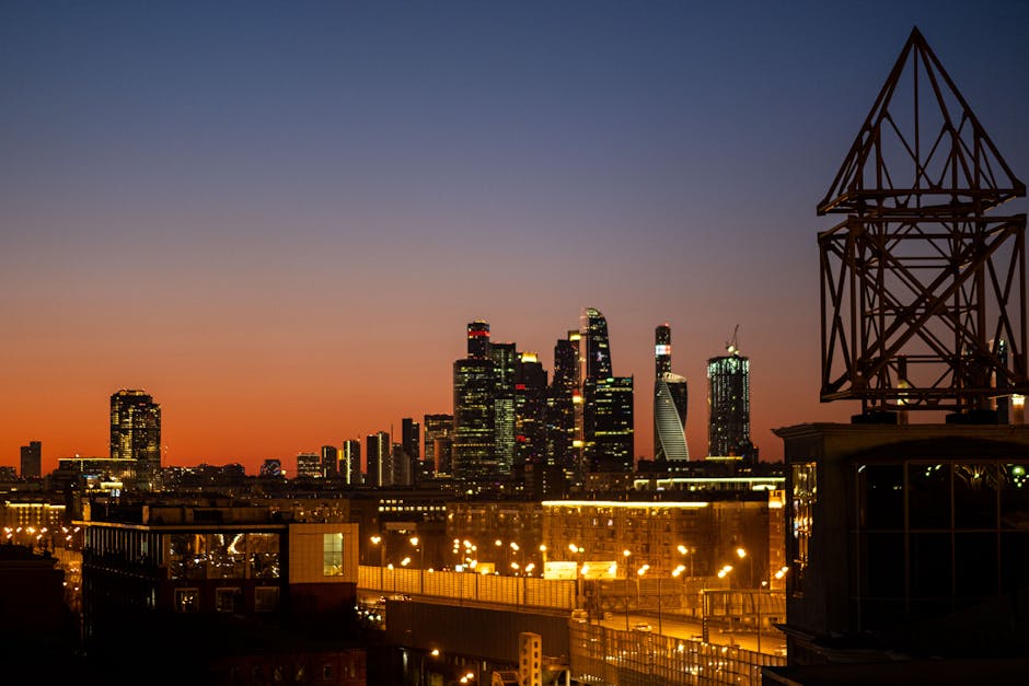 A futuristic city skyline illuminated by vibrant lights at dusk.
