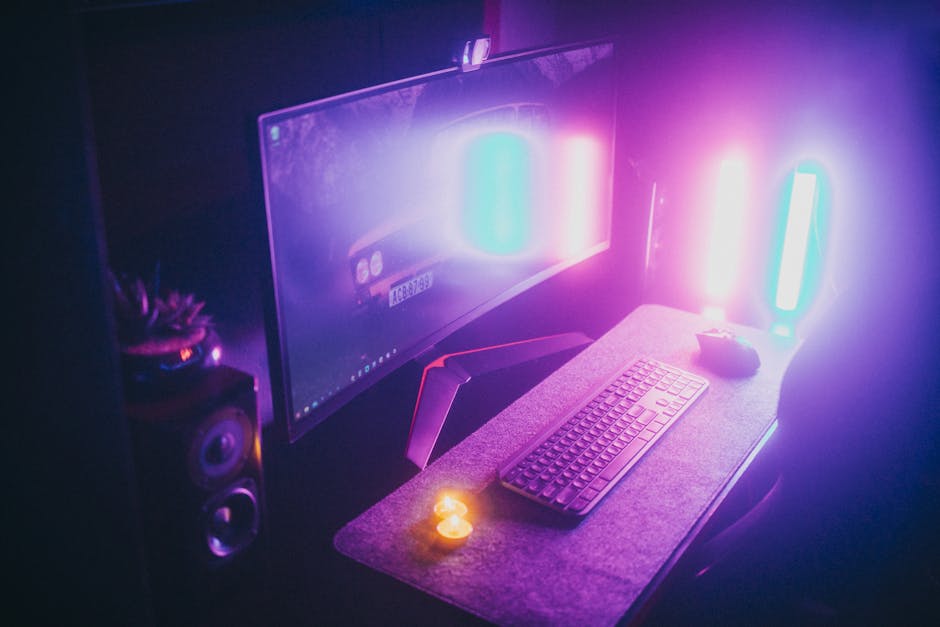 A colorful gaming setup with a chair, keyboard, and illuminated screen.