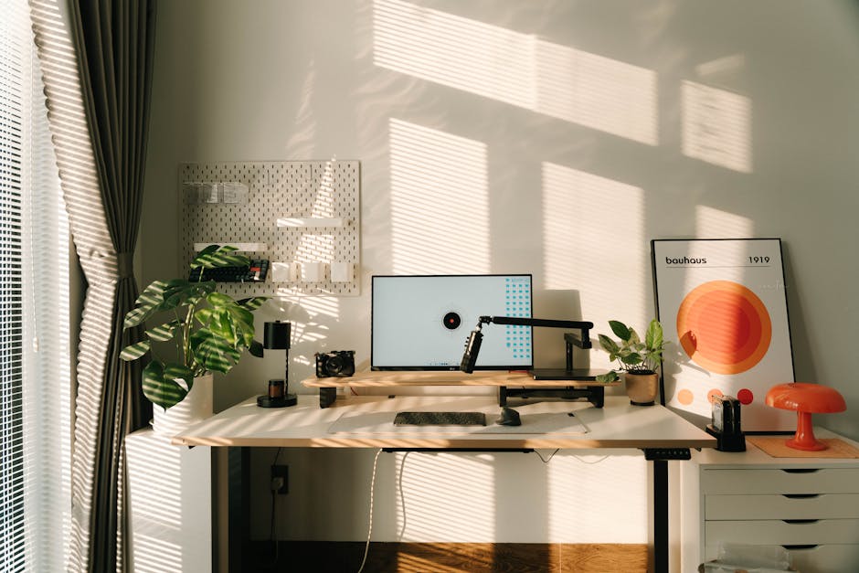 A modern workspace with a computer and vibrant abstract art on the wall.