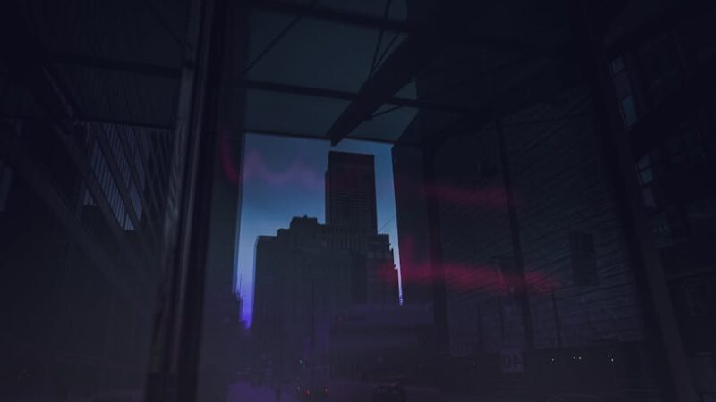 City skyline at dusk with vibrant lights reflecting on glass buildings.