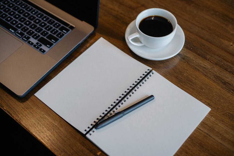 A cozy modern workspace with a laptop and notepad on a desk.