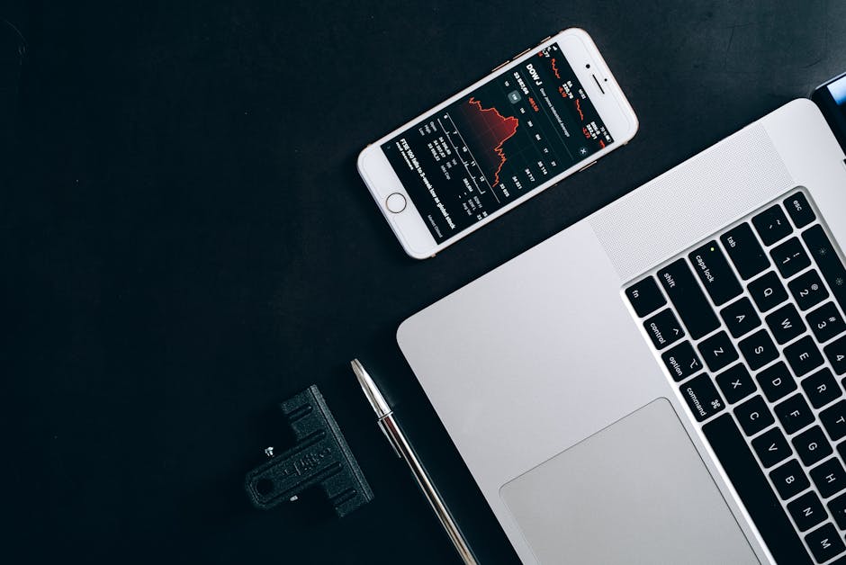 A modern workspace with a laptop and financial charts on a desk.