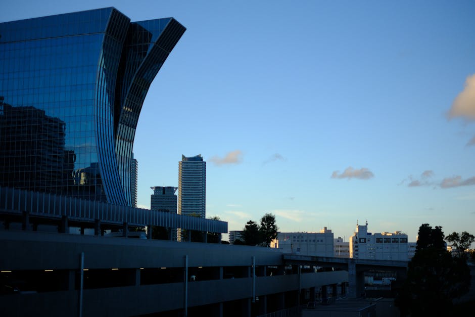 A skyline of a modern city with illuminated buildings at dusk.