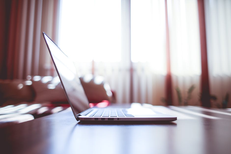 A modern workspace with a laptop, tech gadgets, and financial documents.