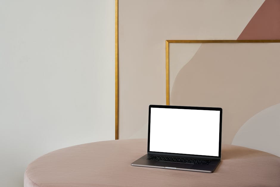 A modern workspace with a laptop and abstract geometric shapes.